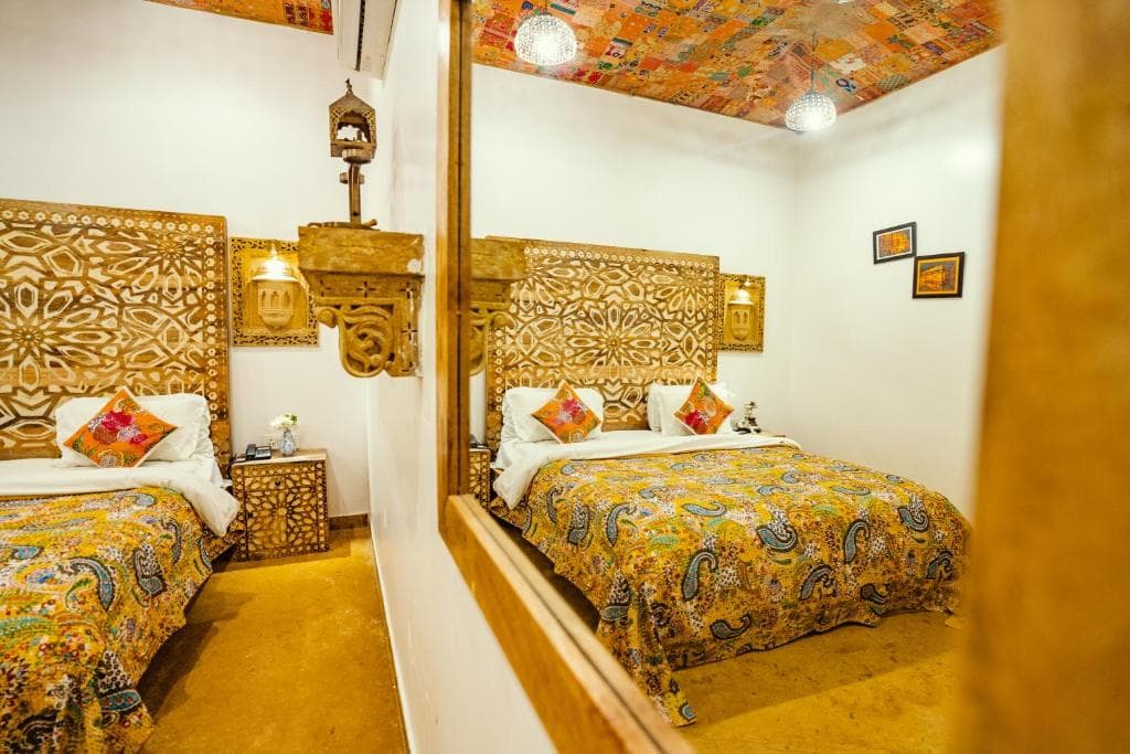 A room with a hand-painted ceiling and floral bedding