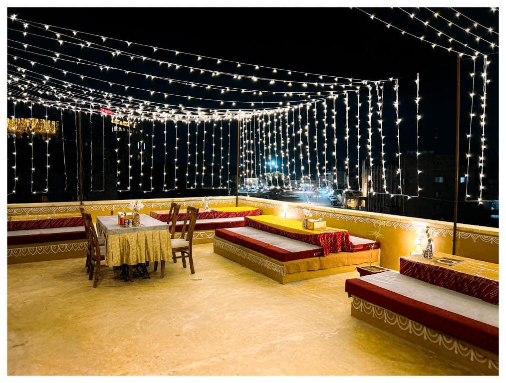 The rooftop under strings of fairy lights at night